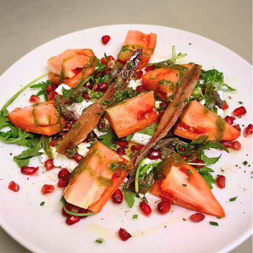 Ensalada de burrata con tomate, anchoas y granada